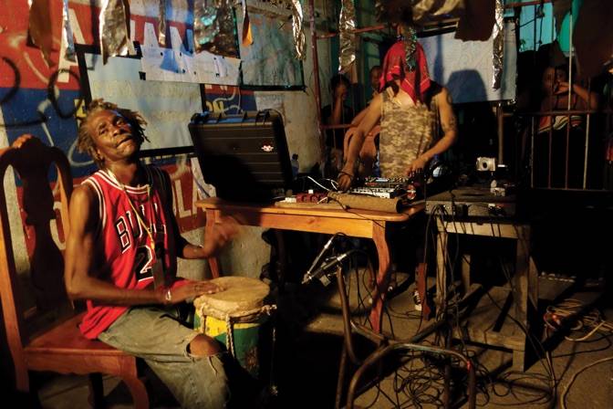 Jean-Claude Saintilus aka Claude playing drums with Jean-Louis Huhta from Dungeon Acid on Rue du Magasin de l'Etat, 3rd Ghetto Biennale 2013, Port-au-Prince, Haiti Photo: Per Huttner